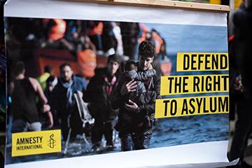Protesters hold placards at the Defend the Right to Asylum