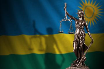 Rwanda flag with statue of lady justice and judicial scales
