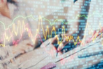 Business woman writing information about stock market in notepad